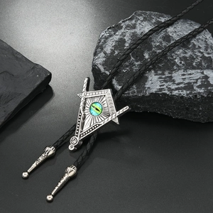 Detalle de corbata bolo masónica plateada con ojo azul sobre fondo de piedra negra