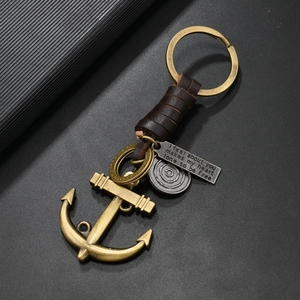 Detail of vintage anchor keychain with brown leather wrap and engraved bronze metal plates