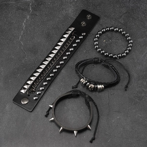 Detail view of 4-piece punk bracelet set with metal studs, chain, and skull charms