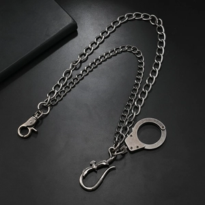 Détail d'une chaîne de pantalon en métal argenté avec pendentif menottes et crochet aigle