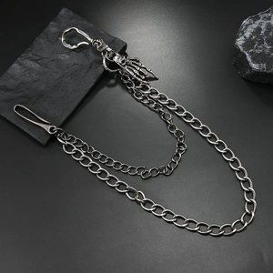 Detail of silver skull and skeletal hand charms on punk style double-layered waist chains