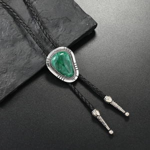 Detail of vintage bolo tie with green malachite stone and silver engraved metal clasp