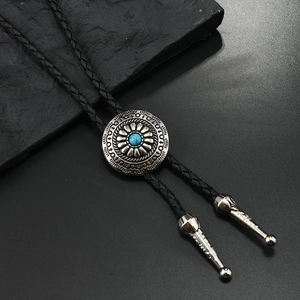 Detalle de una corbata de bolo vintage con piedra turquesa y cordón de cuero negro trenzado