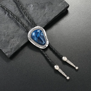 Macro detail of silver bolo tie with blue marble stone and braided leather cord