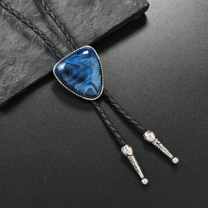 Detailansicht der Bolo-Krawatte mit blauem Stein und silbernen verzierten Metallspitzen