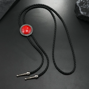 Vintage Bolo Tie with red gemstone inlay and black braided cord on a dark background