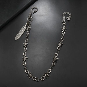 Detail of vintage silver punk hip-hop waist chain with feather pendant and thorn links