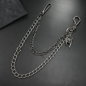 Detail of silver punk pant chain with double metal links, skull and bone hand charms