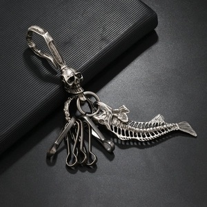 Detail of vintage metal keychain with gothic skull hook and fishbone charm accessory