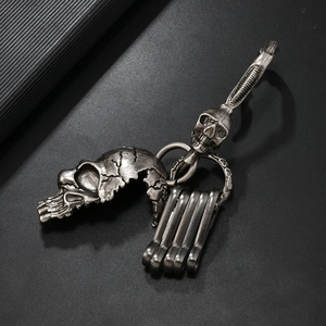 Detailed macro shot of vintage silver skull pendant keychain with metal lobster clasps