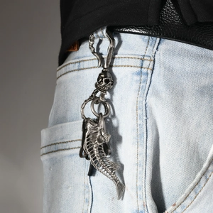 Gothic silver fish skeleton and skull keychain hanging on denim jeans belt loop