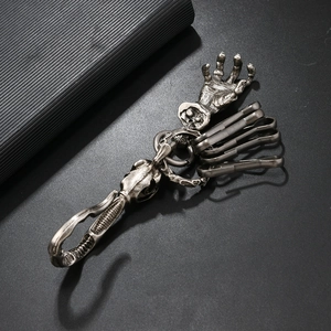 Détail d'un porte-clés main de squelette gothique en alliage antique avec design de crâne