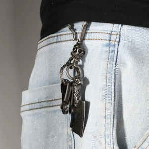 Vintage skull hook and cleaver pendant keychain accessory on light blue denim jeans