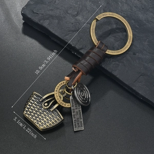 Detail of vintage bronze keychain with leather wrap, basket charm and horseshoe tag
