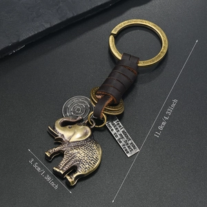 Detailed close-up of retro bronze elephant keychain with braided leather strap and engraved metal tags