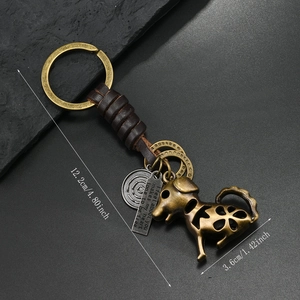 Retro bronze metal dog keychain with dark brown leather strap and engraved tag