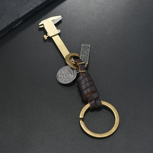 Porte-clés pied à coulisse en bronze vintage avec bracelet en cuir tressé marron et breloques