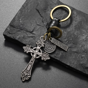Macro shot of vintage metal cross pendant and leather wrap on a rustic stone background