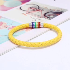 Detail eines gelben geflochtenen Lederarmbands mit Regenbogen-Magnetverschluss und Metalloptik