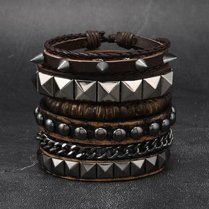 Detail view of multi-layer punk bracelet featuring leather braids and metal studs