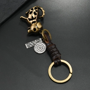 Detail of vintage bronze dog charm and brown braided leather rope keychain