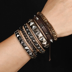 Detailed shot of punk layered leather bracelets with metal studs, chains and wooden beads