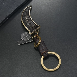 Detail of vintage bronze hook pendant and brown braided leather strap keychain