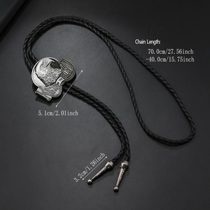 Detail van western bolo tie met gegraveerde arend en gevlochten zwart kunstlederen koord