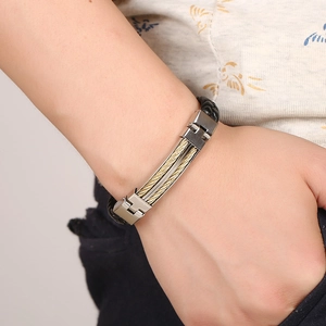 Close-up of men's braided leather bracelet with golden steel wire and silver buckle