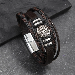Macro shot of Viking compass metal buckle and multi-layer braided leather bracelet