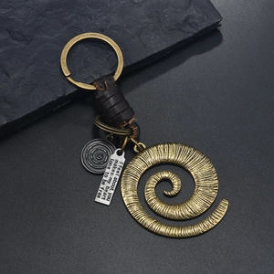 Macro shot of vintage bronze spiral keychain with woven leather strap and metal tag