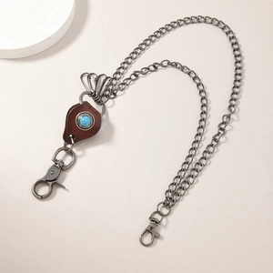 Detail of silver dual chain with heart leather patch and turquoise stone for jeans
