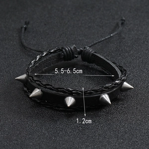 Détail d'un bracelet punk en cuir avec des clous argentés et cordon de serrage réglable