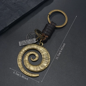 Detailed view of vintage bronze ginkgo leaf keychain with leather weave and size markings