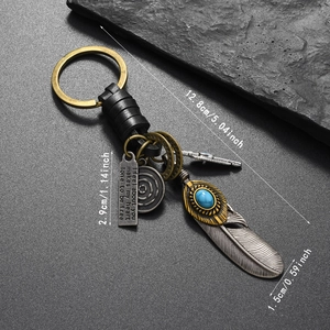 Detailed macro view of vintage bronze feather and turquoise bead on woven leather keychain