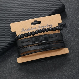 Detail of four-piece black leather and beaded bracelet set on kraft paper display card