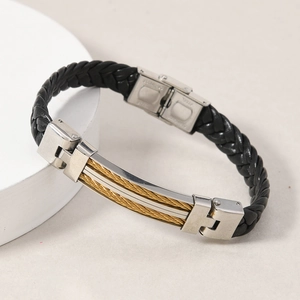 Detail of men's leather woven bracelet with stainless steel plate and golden wire inlay