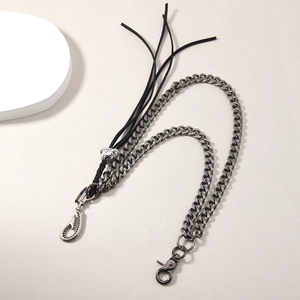 Détail de chaîne gourmette argentée avec gland noir et tête de mort pour style punk
