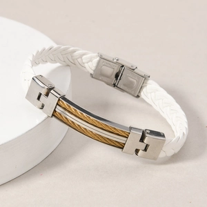 Close-up of white woven leather bracelet with stainless steel gold wire cable detail