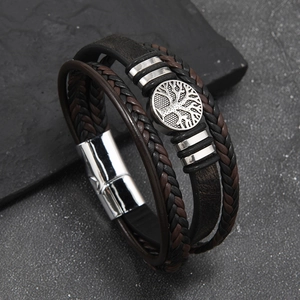 Detail of multi-layer woven leather bracelet featuring a silver Tree of Life charm and magnetic clasp