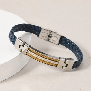 Detail view of woven blue leather bracelet with gold cable inlay and stainless steel buckle