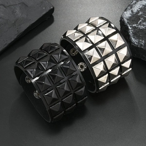 Close-up of punk style bracelets with square pyramid studs in black and silver finish