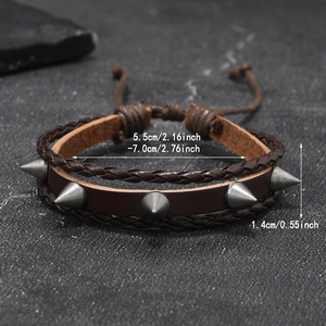 Détail macro du bracelet punk en cuir tressé avec des pointes métalliques argentées