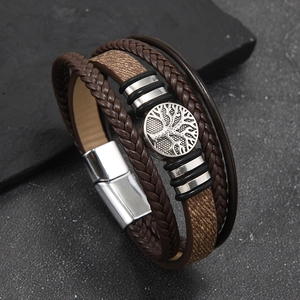Detail view of multi-layer brown leather bracelet with tree of life metal charm and magnetic clasp