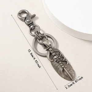 Vintage silver alloy feather and skull keychain with intricate gothic metal engraving