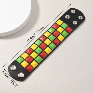 Detail of punk leather bracelet showing colorful pyramid studs and adjustable snaps