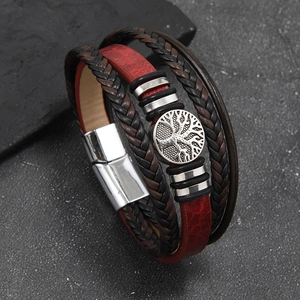 Macro detail of multi-layer leather bracelet with Tree of Life charm and magnetic clasp
