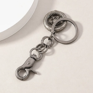 Macro detail of retro alloy keychain with star motif and roman numerals on textured surface