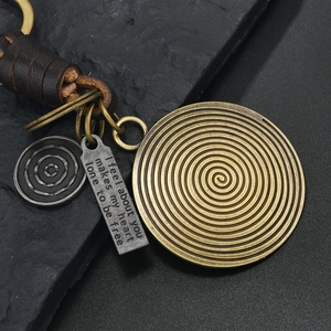 Detailed view of vintage bronze ginkgo leaf keychain with braided leather and metal plates