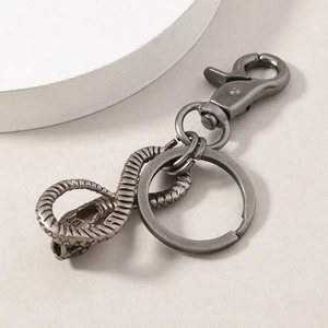 Detailed close-up of antique silver snake keychain with intricate scale textures